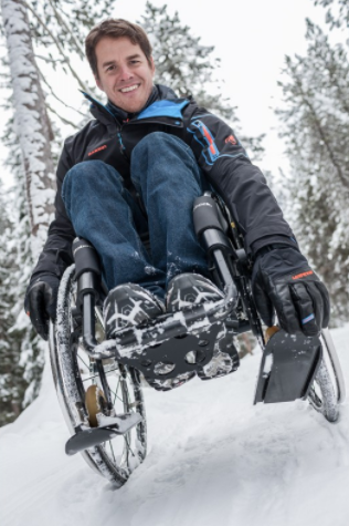 Diapo 4 : Personne utilisant un fauteuil roulant équipé de mini-skis dans la neige.