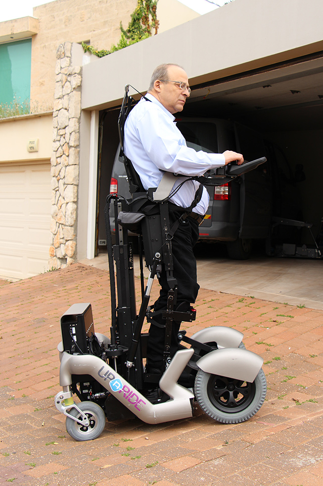 Diapo 4 : Personne se déplaçant dans la rue à l'aide d'un fauteuil UPnRIDE, en position debout.