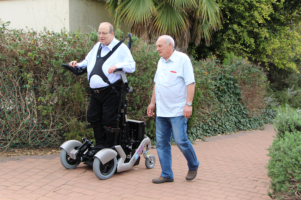 Diapo 5 : Personne se déplaçant dans la rue à l'aide d'un fauteuil UPnRIDE, en position debout.