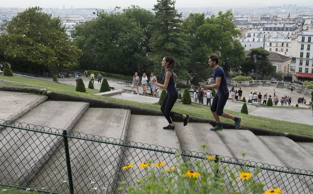 Diapo 4 : Deux personnes portant un T-shirt Percko, courant sur un escalier en extérieur.