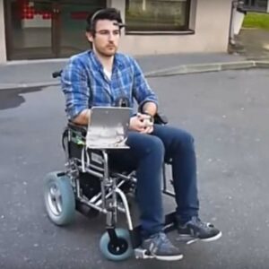 Image d’une personne sur un fauteuil roulant avec le dispositif de Neuromoov sur sa tête