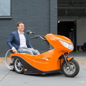 Personne en fauteuil roulant, s’arrimant à un Pendel Mobility Scooter.