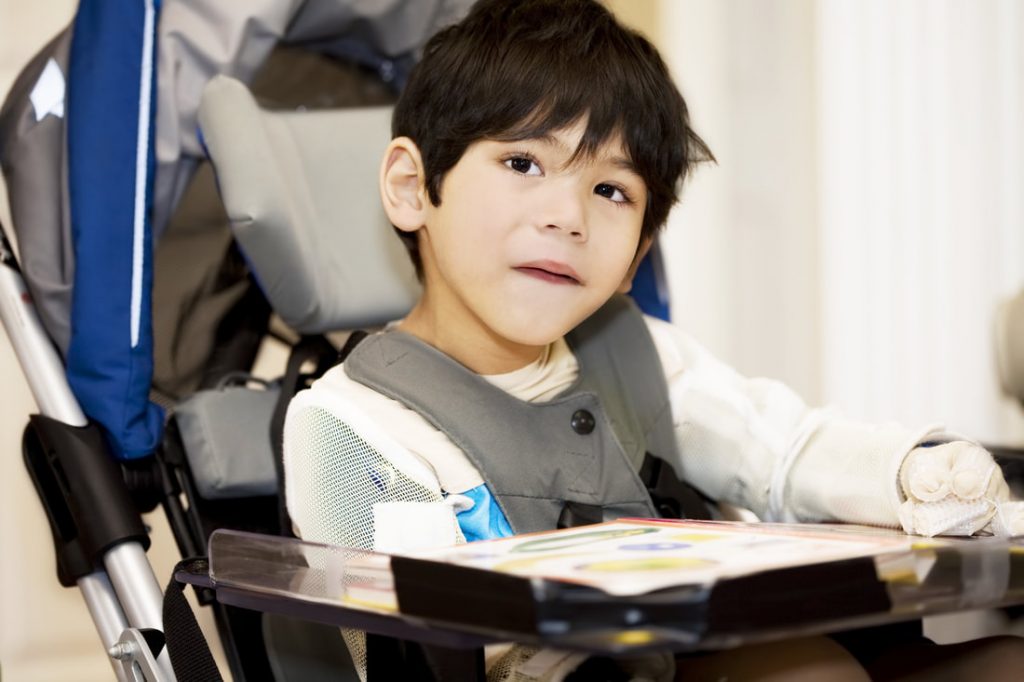 Diapo 2 : Enfant en fauteuil roulant, regardant la caméra.