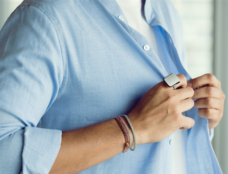 Diapo 7 : Personne portant une bague Orii à la main droite, boutonnant sa chemise.