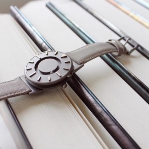 Montre The Bradley, posée sur des livres.