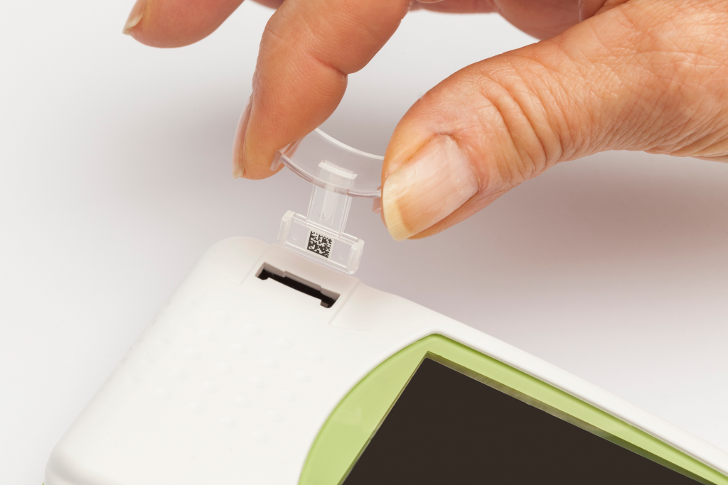 Diapo 3 : Personne introduisant une languette plastique de test sanguin dans un appareil LabPad.