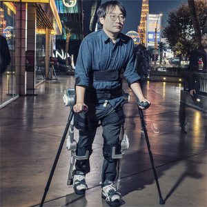 Personne se déplaçant grâce à l’exosquelette H-MEX en extérieur.