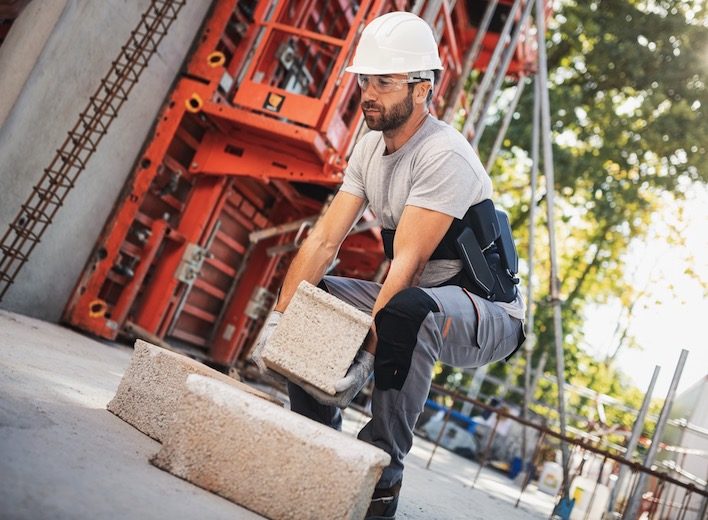 Diapo 6 : Homme portant un parpaing avec l'exosquelette sur lui