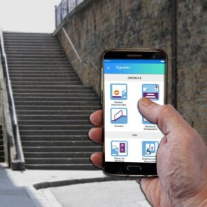 Personne utilisant l’application StreetCo sur un smartphone qui lui indique la présence d’escaliers en face d’elle