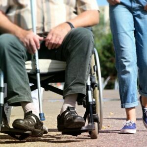 Photo de deux personnes qui se baladent dont une en fauteuil roulant