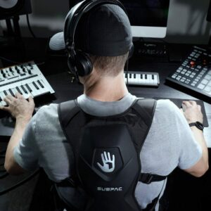 Photo d’un homme en studio de musique avec un casque sur les oreilles et le gilet Subpac