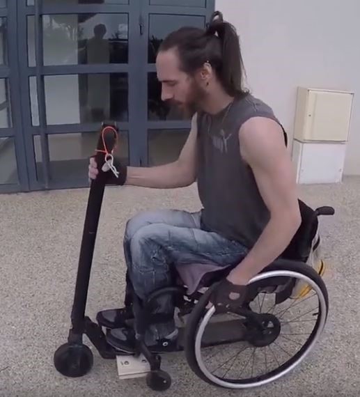 Diapo 3 : photo qui représente un homme utilisant la trotinette electronique avec son fauteuil