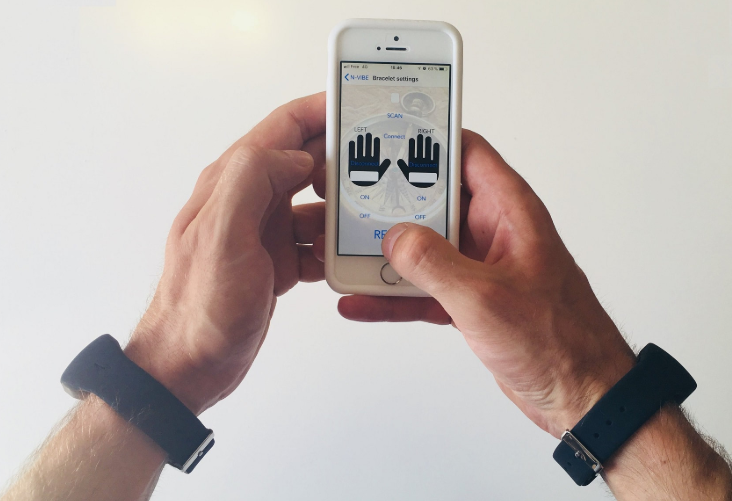 Diapo 3 : mains qui tiennent un téléphone avec l'application N-Vibe