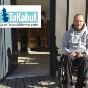 Photo d’un homme en fauteuil roulant devant une maison avec à côté le logo de TaKahut où il y a marqué en-dessous « Là où l’accessibilité vous porte »