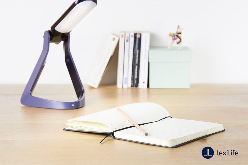 Diapo 3 : photo qui représente la lexilight avec un cahier sur un burea