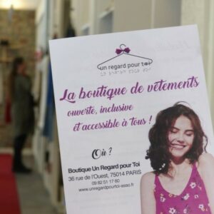 Image de l’intérieur d’un magasin « Un regard pour toi » avec un flyer de la boutique en premier plan