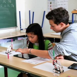 Photos de deux personnes dont une petite-fille essayant un petit robot Crocos Go Digital