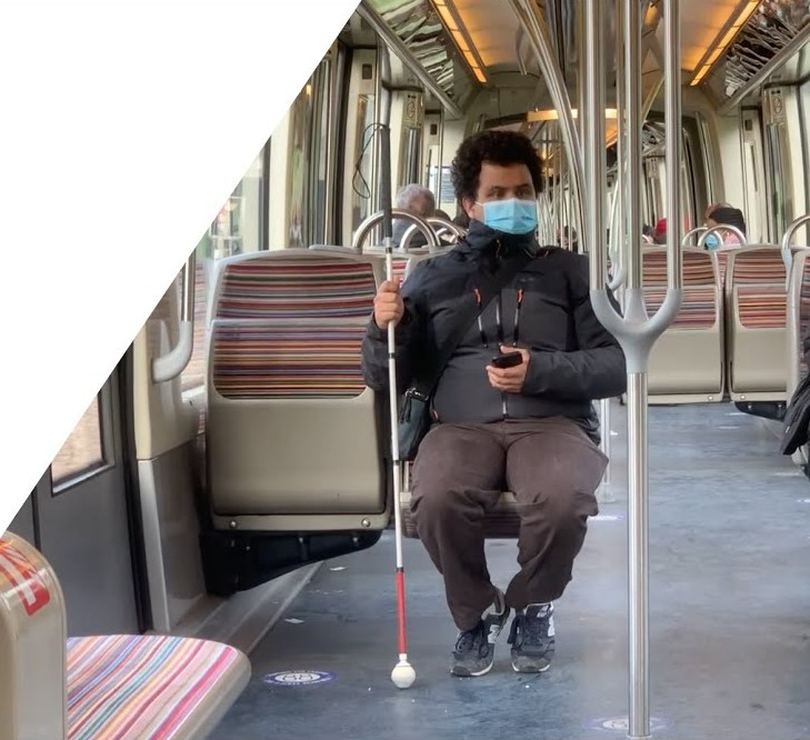 Diapo 4 : Personne malvoyante assise dans un métro avec l'application Ezymob en main sur son téléphone