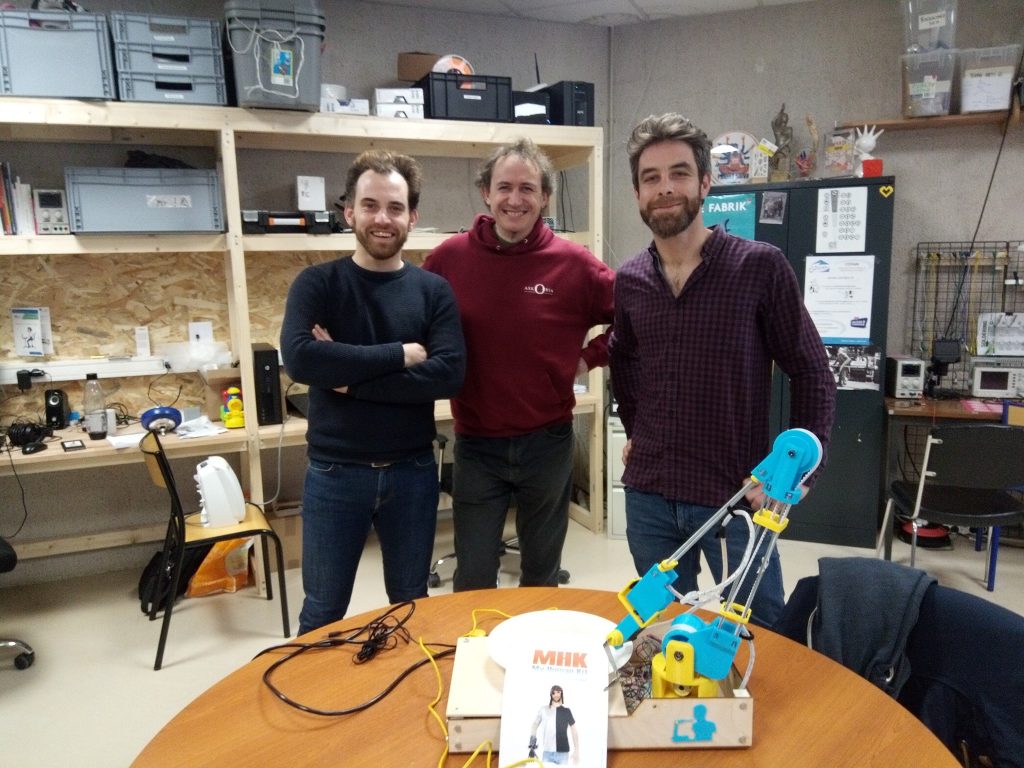 Diapo 2 : Trois personnes et le bras robotique de MakerGo, réalisé dans le fablab de My Human Kit