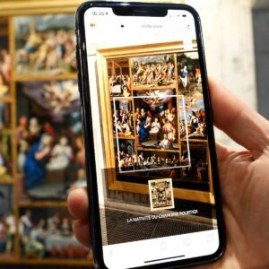 Personne utilisant l’application Livdeo au musée sur son smartphone pour la description d’un tableau