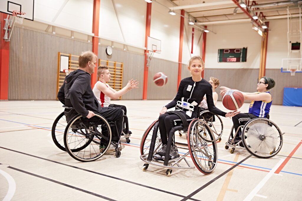 Diapo 4 : Personnes jouant au basket-ball et portant le Exopulse Mollii Suit sur eux