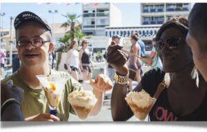 Deux personnes mangeant un glace, dont un garçon atteint d'un handicap