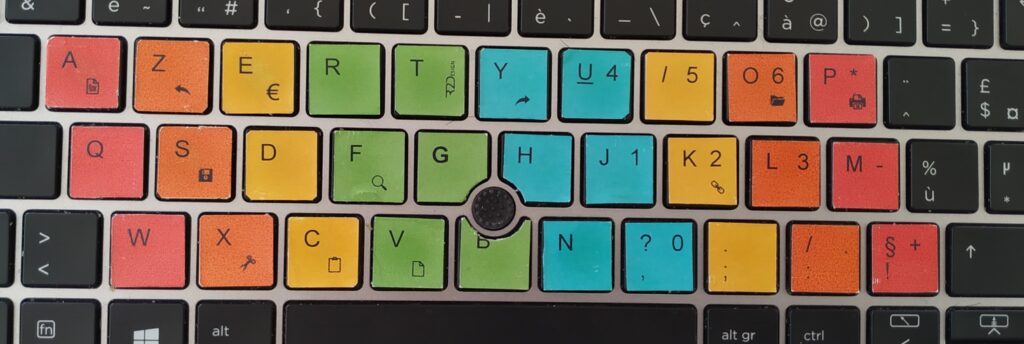 Diapo 2 : Clavier KeyDys avec certaines touches en couleurs (rouge, orange, jaune, vert, bleu)