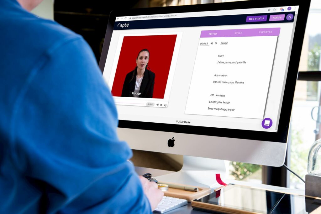 Diapo 3 : Photo d'une personne devant un ordinateur qui met des sous-titres sur une vidéo avec Capté