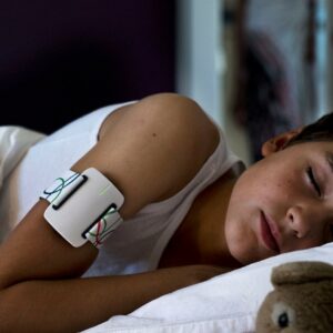 Photo d’un enfant qui dort avec le bracelet NightWatch autour de son bras